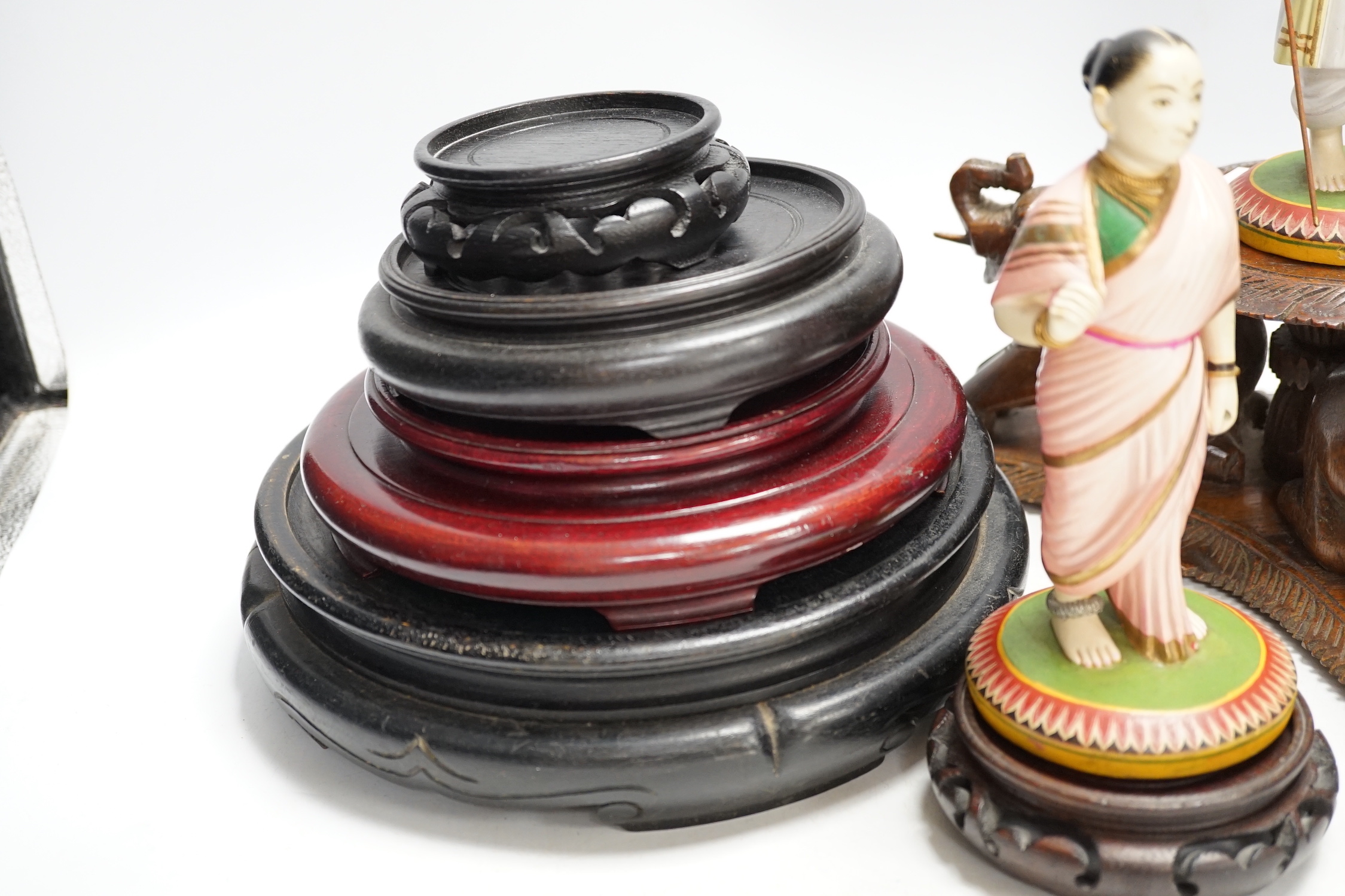 Two Indian carved and painted wood figures, an Indian or Burmese carved wood stand another various wood stands, largest 24cm in diameter